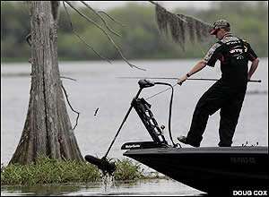 Mike McClelland pulls up his trolling motor as he spots a submerged tree to his liking.