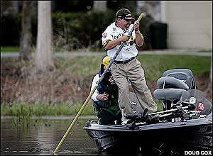 Preston Clark leans on the pole to free his boat in shallow water. 