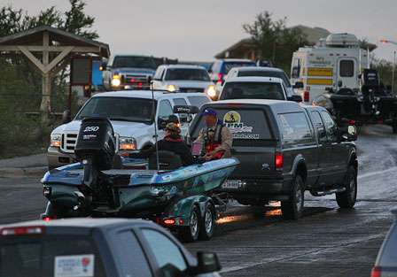 Rick Morris is pulled up the ramp, while several of the Elite Series pros drive down the boat ramp to load their boats.