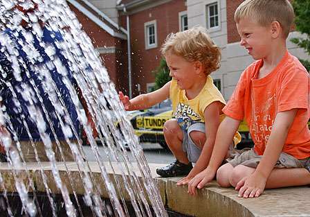 Marty Robinson's boys, Mitchell and Marshall, play in the fountain in front of the community complex.