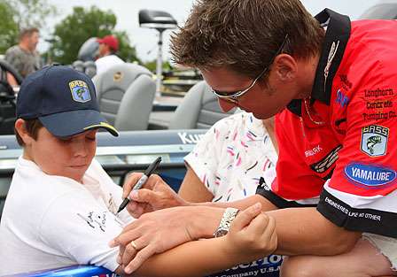 Brian Clark signs Seth Thomas' arm, as he and the pro talk fishing.