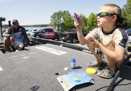 Cal Lane, 6, plays with a bubble blower, but it needed batteries, as his dad Chris watches.
