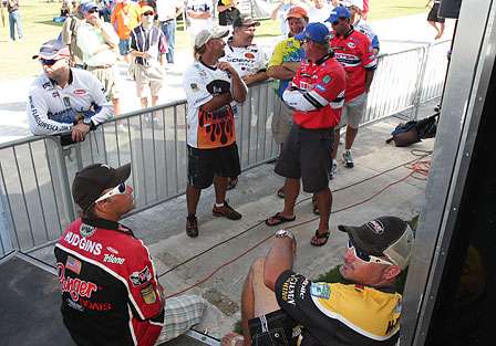 Some of the pros make their way back around to watch the standings as the few remaining anglers weigh in.