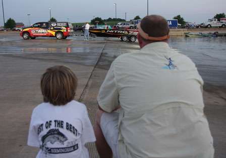 Daniel Casteel II and his father sit and watch Kevin VanDam launch his boat in the early morning hours of Day Three.