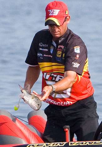 After unclipping a smaller fish pulled from the livewell, VanDam tosses it over the side of the boat.