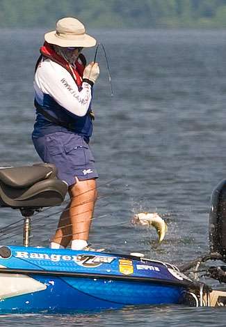 Co-angler Marcos Malucelli was dressed for bass warfare on Day Three and fights a good fish to the boat.