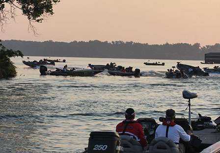 Matt Reed watches as he idles toward mass hysteria. In the background Kevin VanDam takes his hole shot as he is covered up by spectator boats.