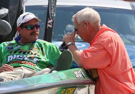 Shaw Grigsby talks with Mr. Berry from Costa Del Mar as he waits in line to weigh in on Day One.