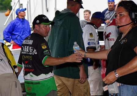Mike McClelland accepts a bottle of water from Director of Angler Relations, Janet Bell. McClelland would finish Day Two in third place.