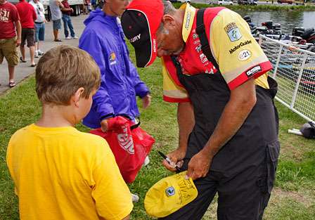 Boyd Duckett signs an autograph for a young fan backstage. Duckett would finish 36th on Day Two.