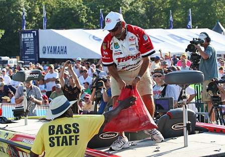 Longtime BASS staff member, James Pooley Dawson, reaches to help Paul Elias with his weigh-in bag. Elias finished 5th with 75 pounds, 14 ounces. 