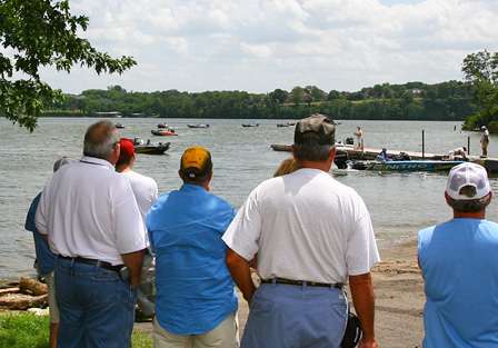 Spectators begin to gather near the boat ramp to watch the field of contenders load their fish into weigh-in bags.