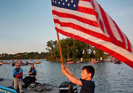 Young BASS fan and fisherman Chase McDonald holds Old Glory high as the national anthem rings through the quiet morning air.