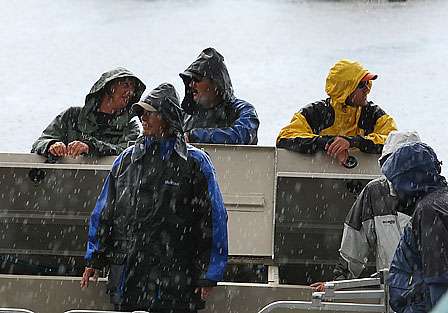 BASS officials wait near the live-release boat in a driving rain for the first fish to hit the scales. 