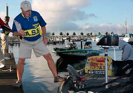 Chuck Harbin, BASS Tournament Manager, pushes Michael Iaconelli's boat away from the dock to make room for more boats.