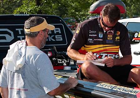 Kevin VanDam, who is gunning for Todd Faircloth in the race for the Toyota Tundra Bassmaster Angler of the Year title, signs an autograph for Tim Wertz.