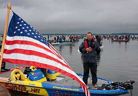 Randy Allen honors the flag as the National Anthem echoes through the cove at Oneida Shores.