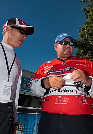 Ken Hoover (left) talks with Bill Lowen as he checks his weight slip from the weigh in. Lowen slid safely into ninth place with 41 pounds, 13 ounces and will fish the final day of the Champions Choice.