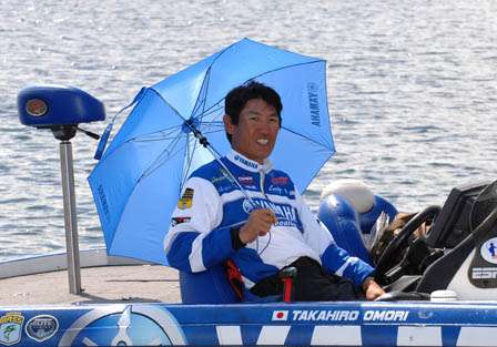 Elite pro and former Bassmaster Classic winner Takahiro Omori relaxes under an umbrella as his two JWC anglers fish.