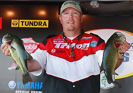 Co-angler Kirk Smith shows off two of the bass he brought to the scale on the final day, putting him in the early lead and also on the hot seat.