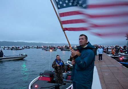 Eric Nichols, part of the BASS tournament staff, presents the colors for the singing of the national anthem, performed by co-angler Jennifer Nevans (off camera).