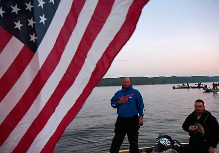 Elite Series pro Bobby Lane and his co-angler, Michael Bradford, honor the flag while the national anthem plays.