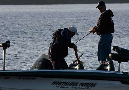 Pro Arnie Lane removes a hook from his second fish of the morning as his co-angler, Jason Shaurer, looks on.