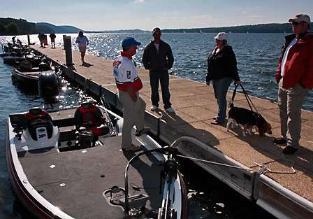 Randall Tharp talks about his day of fishing as he waits at the dock for a 'Berkley Bag' so he can bag his fish.