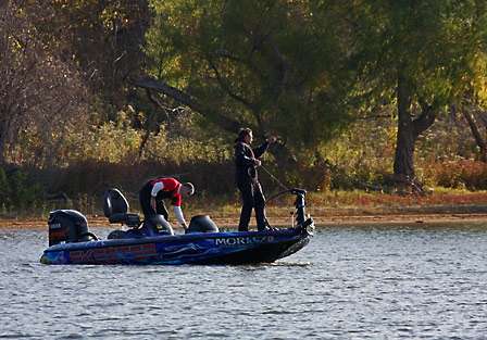 Bassmaster Elite pro Brian Clark motions to his co-angler as he pulls the trolling motor to make a move.