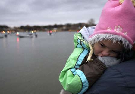 A child gets some warmth and rest as the boats get ready for take-off.