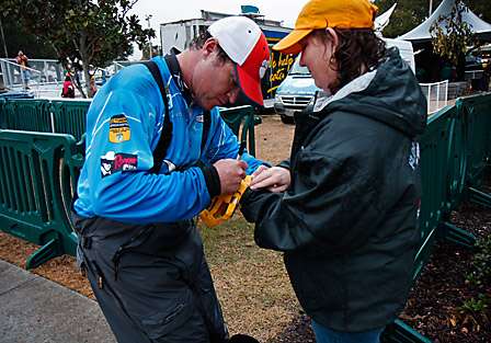Wade Grooms signs an autograph for a volunteer after getting an official weight on his fish.
