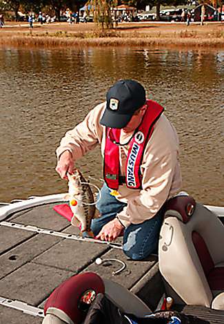 Ben Quisno takes weight markers from the bass in his livewell before placing them into the tournament bag.