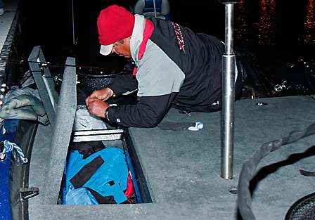 Joe Clements uses a light inside of his rod box to tie on a lure just prior to launch.