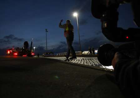 A TV cameraman watches as an official directs a boat trailer down the ramp at the Red River South Marina & Resort. 
