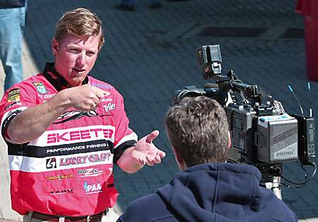 Kelly Jordon does one of many interviews on media day; he is explaining the safe and harmless way to handle large bass, so that they can be released and caught another day.