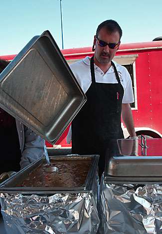 Chuck Satori of Shavers Catering raises the lid on a pot of gumbo, a Louisiana staple. 