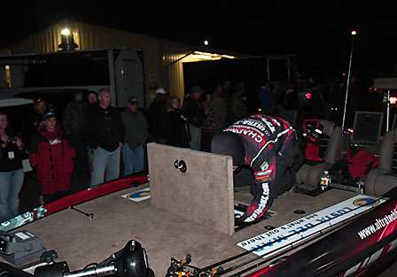 Fans look on as Casey Ashley digs into one of his compartments as his boat is pulled in front of the Red River Marina store.