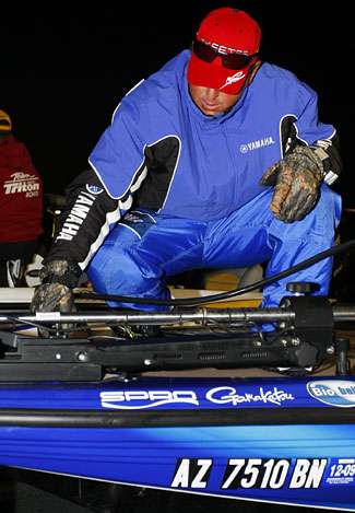 Dean Rojas tries to tweak his trolling motor  on a cold Day One on the 39th Bassmaster Classic.