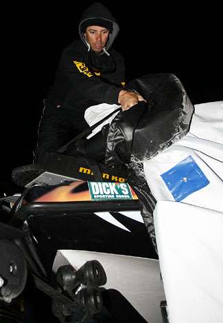 Mike Iaconelli pulls his frozen cover off his boat Friday morning.