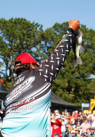 Chris Lane shows a fish to the crowd as he approaches the stage.
