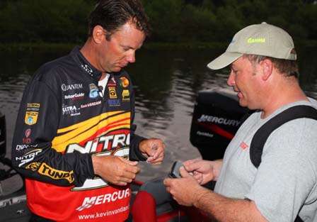Kevin VanDam is outfitted with a microphone by ESPN cameraman James Massey. VanDam leads the event going into the final day.