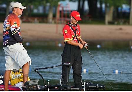 Russ Lane (left) and John Crews visit as Crews makes a cast to test the tuning of a lure on one of his rods.