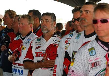 Anglers around the holding tanks stand for the national anthem before taking the stage to weigh their fish.