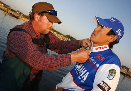 ESPN cameraman Rick Mason mikes up Takahiro Omori, who began the final day in second place, 2-7 behind leader Tommy Biffle.