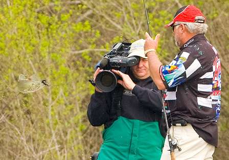 Biffle pulls a fish from the water and gives ESPN cameraman James Massey a closer look.