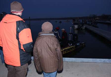 Dan Boehm (left) and his son Danny watch Michael Iaconelli as he pulls to the dock to pick up his co-angler for the day.
