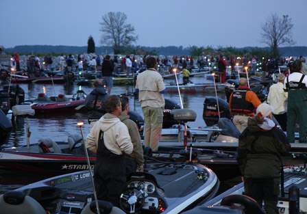 Ingall's Harbor is packed with boats as all of the competitors stand in unison to honor the flag as WBT Tournament Director Deb Wilkinson sings the National Anthem.