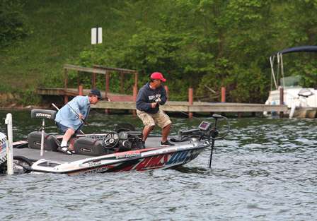 Nearby, Pro Darrin Schwenkbeck fights a bass to the boat as Shawn Meade goes for the net.