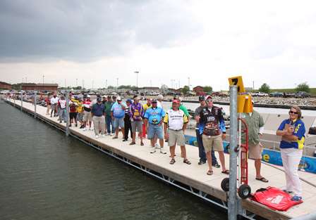 Anglers wait in line at the dock to get their bags as they are called according to their flight number.