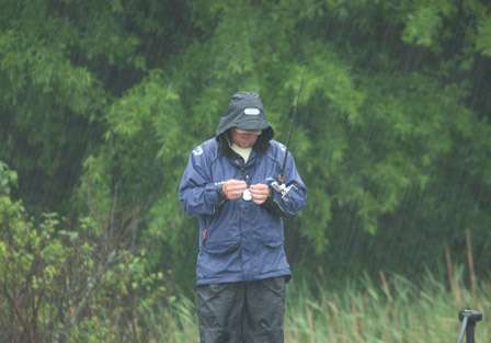 Elite Rookie J. Todd Tucker makes adjustments to his lure as he is pelted with rain.